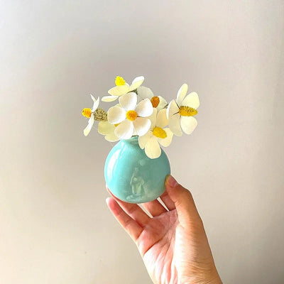 Vase bleue en céramique décorative avec fleurs blancs jaunes