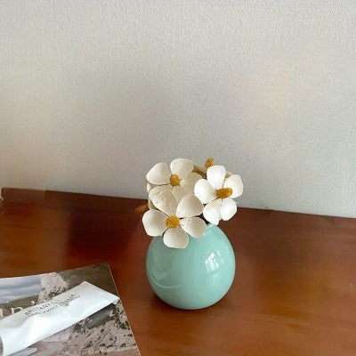 Vase bleue en céramique décorative sur table avec fleurs