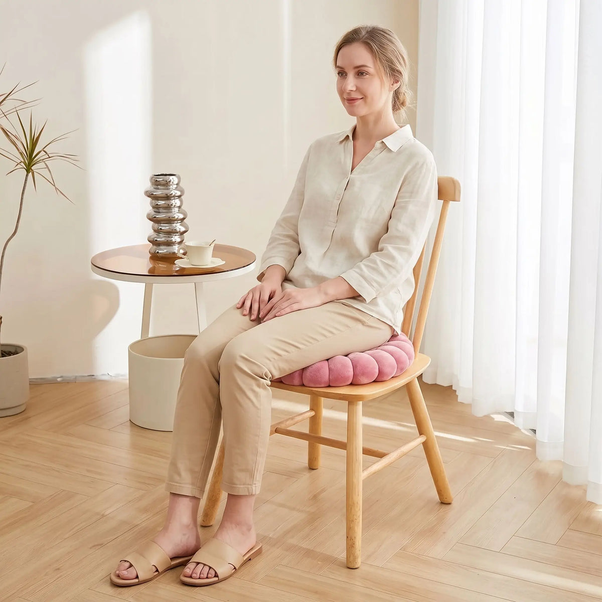 dame assise sur coussin de chaise rose dans un intérieur lumineux
