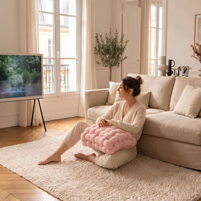 dame devant télé avec les mains sur coussin décoratif pour canapé