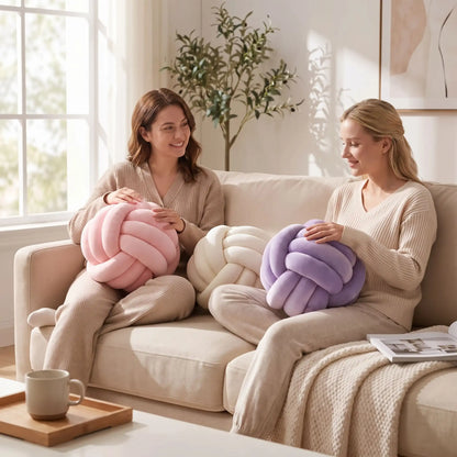 deux femmes dans le canapé tenant coussin décoratif pour canapé