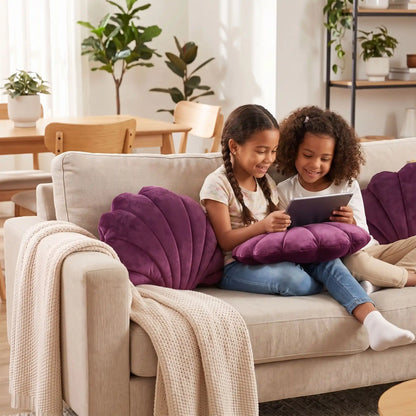 deux fillettes jouent ensemble avec leur tablette  sur coussins pour canapé