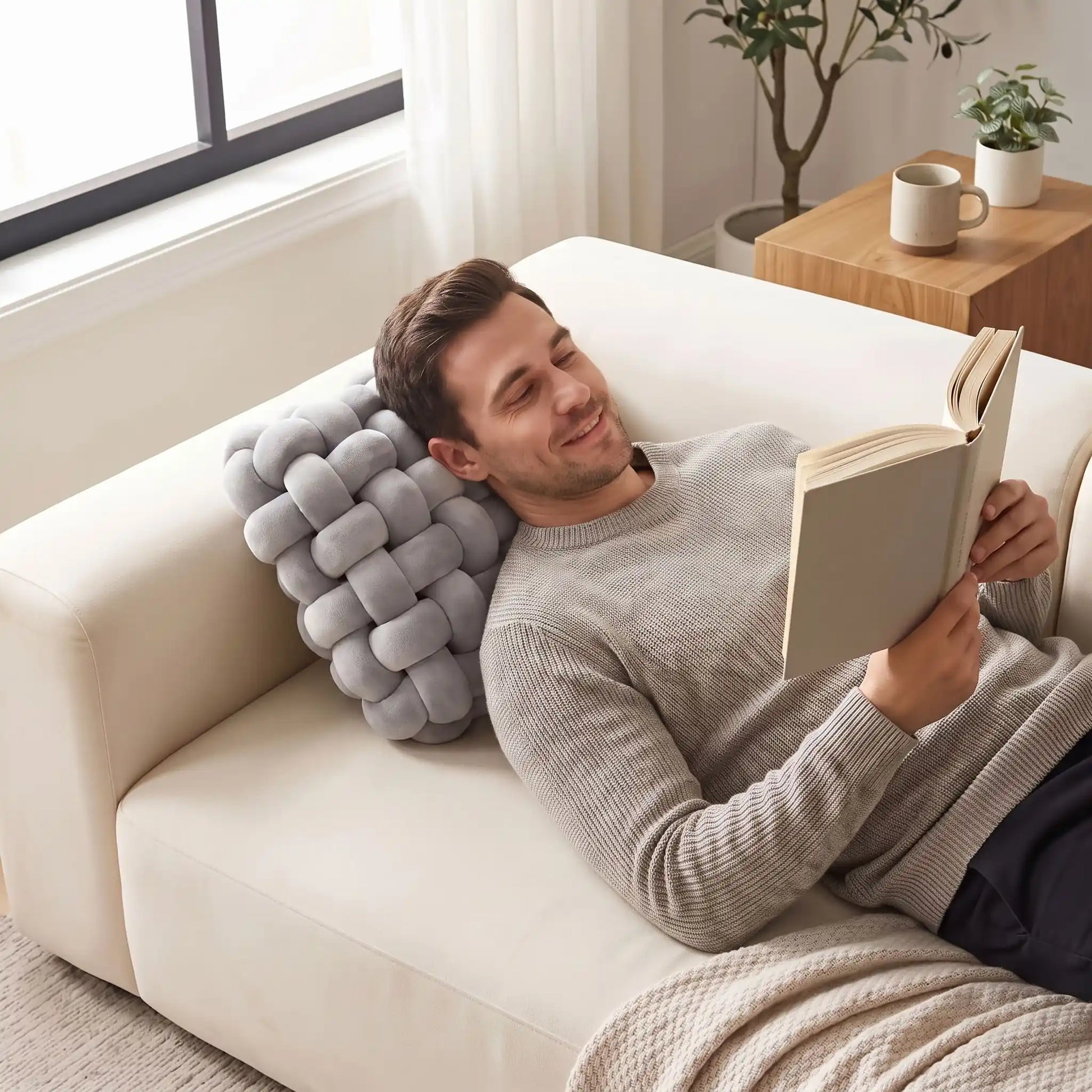 homme lit un roman tête sur coussin décoratif pour canapé